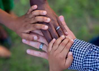 Photo of families' hands on top of each other.